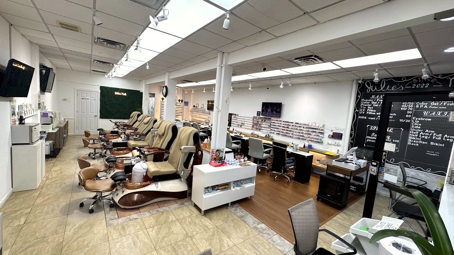 Interior of Julie's Nails with pedicure chairs, manicure tables and the chalkboard menu